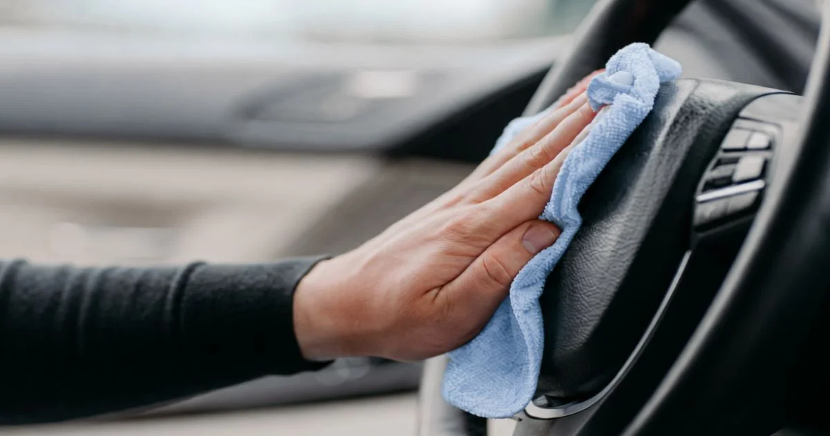 Cleaning car interior with blue microfiber cloth